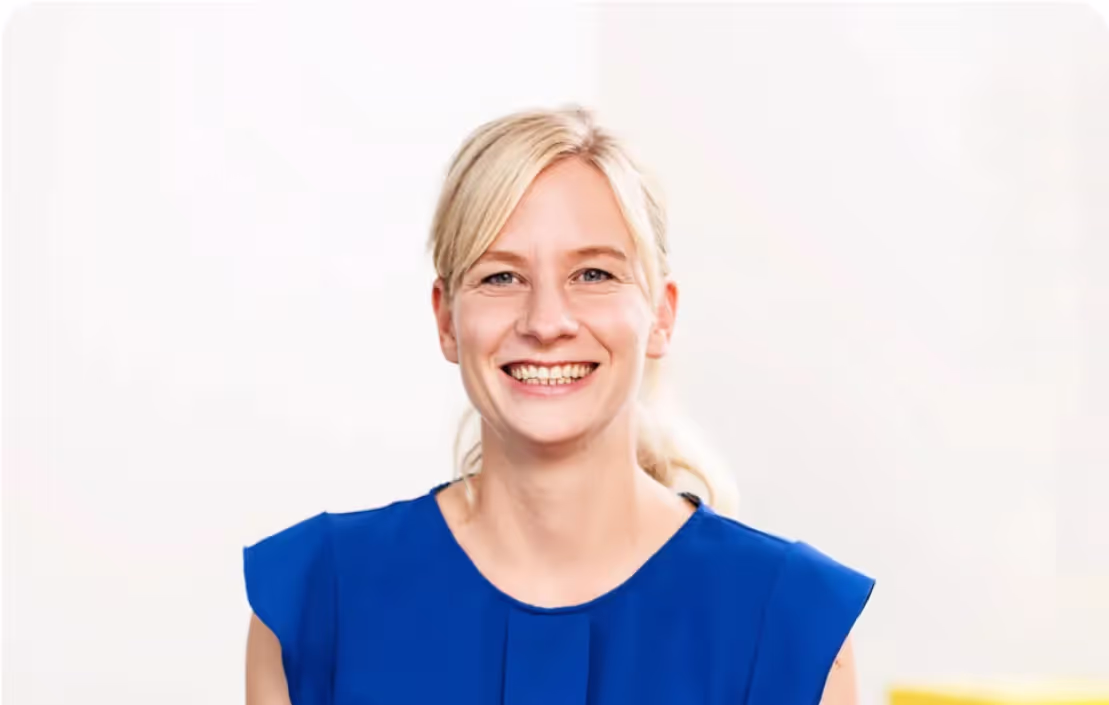 Foto einer blonden Frau mit blauer Bluse